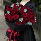 Valentine’s Day bouquet of fresh red roses with eucalyptus, elegant black wrap and red ribbon by Velvet Butterfly Flower Studio in Houston.