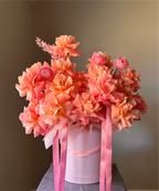 Bouquet of pink flowers in a white box with pink ribbons 