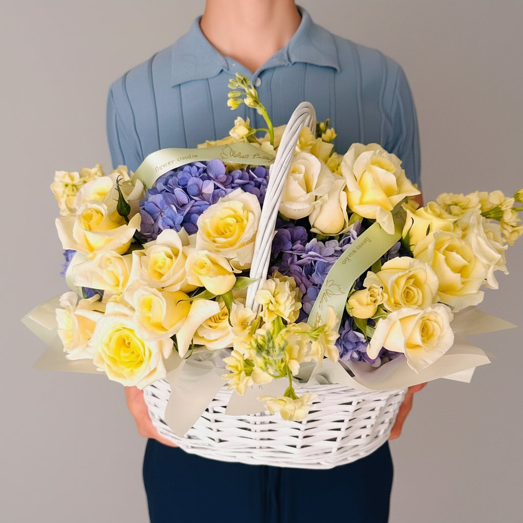 yellow roses and purple hydrangeas in a basket